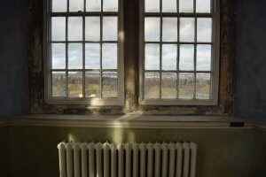 a radiator in front of a bare window.
