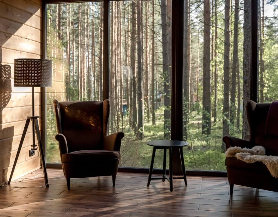 A vacation rental in a wooded area with floor to ceiling windows.